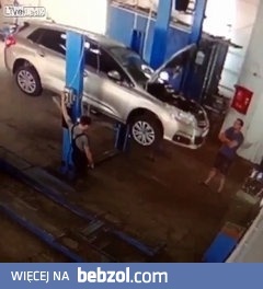 Samochód spada na dwóch mechaników