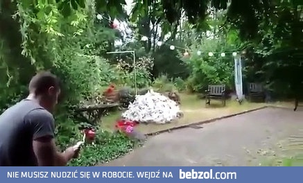 Gość rozpala ognisko w swoim przydomowym ogródku