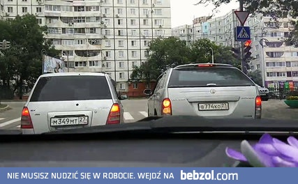 Dwa samochody skręcają na skrzyżowaniu