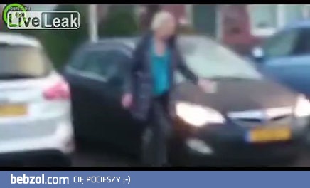 Kobieta usuwa lód z szyby samochodu