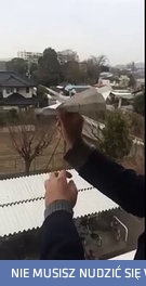 Puszczanie papierowego samolociku z okna, który...