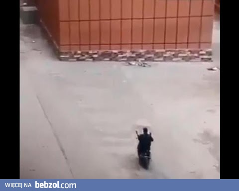 Rowerzysta na skuterze z parasolem